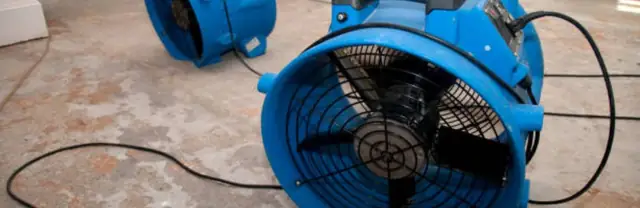 Large blue air mover drying a floor
